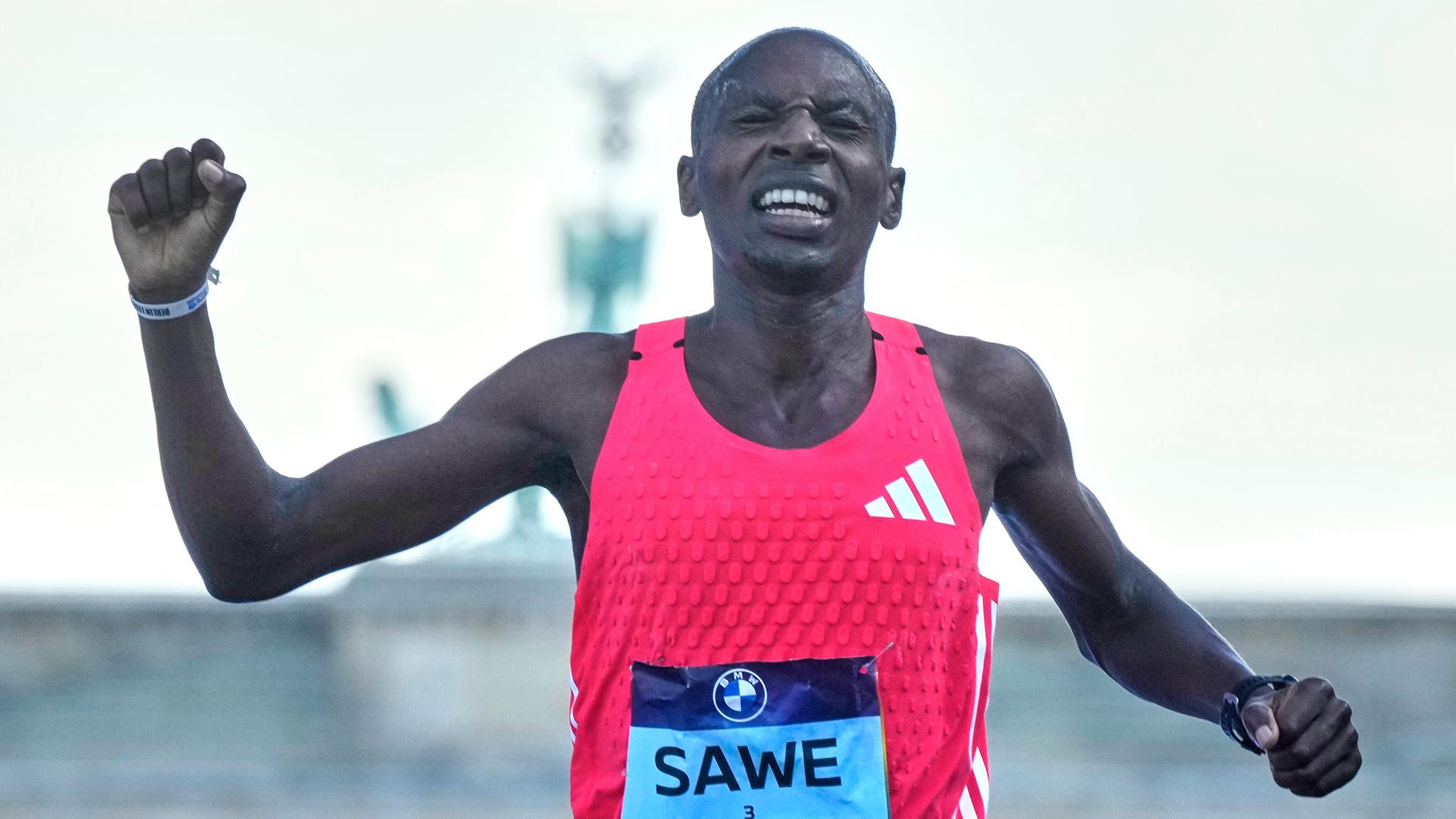 Der kenianische Läufer Sebastian Sawe überquert die Ziellinie beim Berlin-Marathon. Der kenianische Läufer Sebastian Sawe überquert die Ziellinie beim Berlin-Marathon.