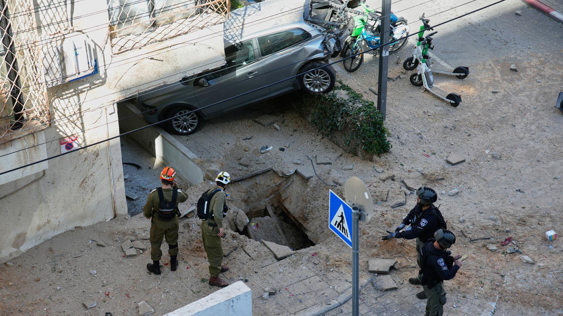 Israelische Sicherheitskräfte inspizieren ein bei einem Luftangriff beschädigtes Gebiet in Tel Aviv.