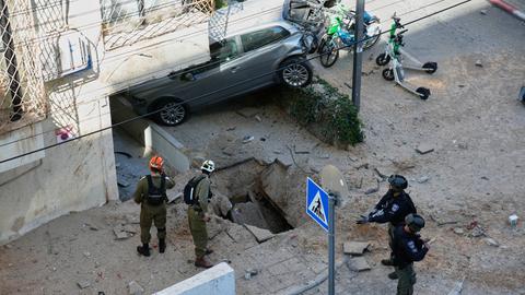 Israelische Sicherheitskräfte inspizieren ein bei einem Luftangriff beschädigtes Gebiet in Tel Aviv.