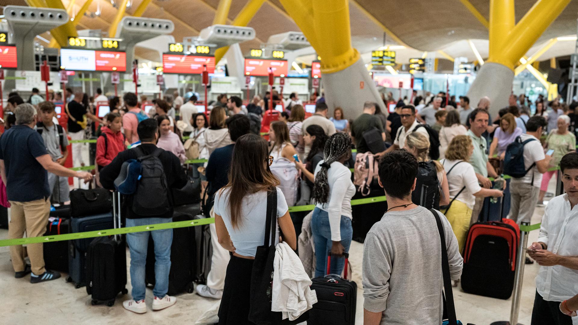 Passagiere auf dem Flughafen Madrid-Barajas warten im Check-in-Bereich, nachdem Update-Probleme beim Unternehmen Crowdstrike Absturz eines IT-Sicherheitssystems zu Ausfällen bei großen Unternehmen auf der ganzen Welt geführt hat. 