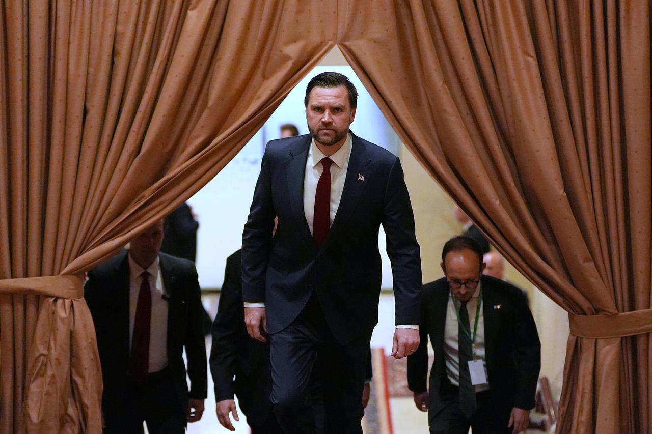 J.D. Vance kommt mit ernster Miene hinter einem Vorhang hervor.