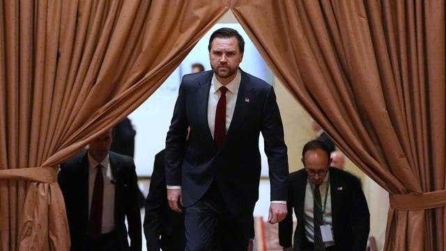 J.D. Vance kommt mit ernster Miene hinter einem Vorhang hervor