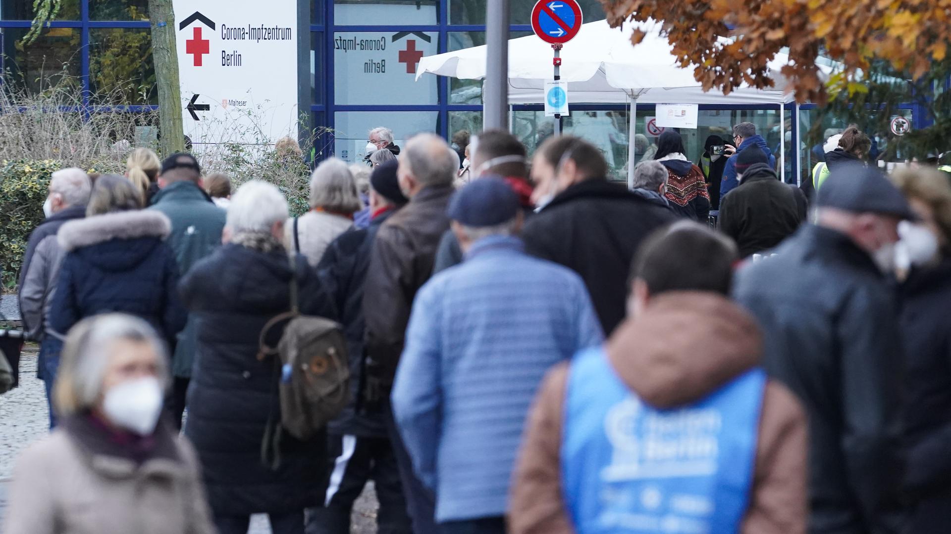 Zahlreiche Menschen in Winterjacken warten vor dem Impfzentrum in Berlin