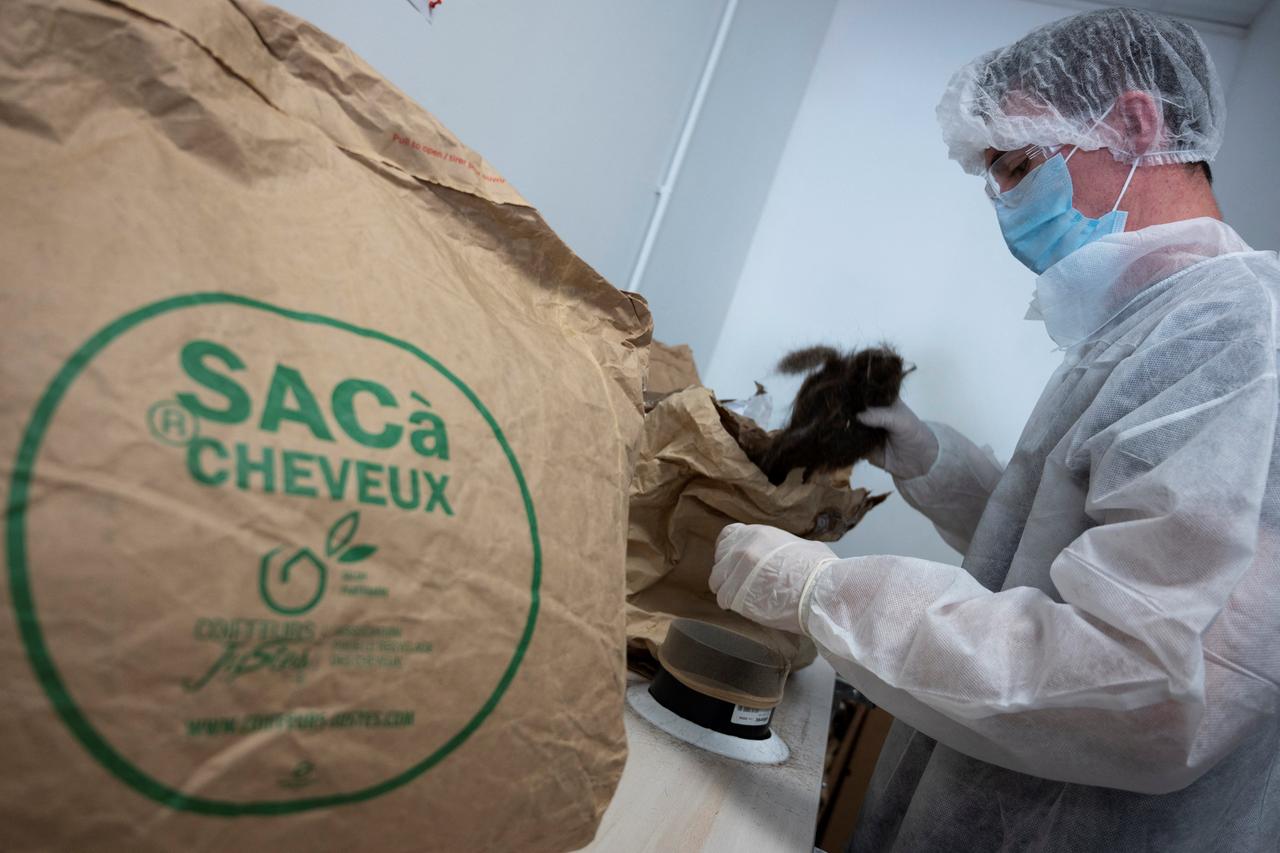 Ein Arbeiter füllt Papiersäcke mit Haaren, die er von Friseuren in Frankreich erhält und die zur Herstellung von Kohlenwasserstoff absorbierenden Schlangen verwendet werden, am 
Sitz der Umwelt- und Recyclingvereinigung "Coiffeurs justes" (faire Friseure) in Brignoles.