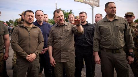 Der ukrainische Präsident Selenskyj (links) informiert sich in der überfluteten Region Cherson.