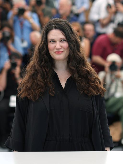 Die deutsche Regisseurin Mascha Schilinski posiert beim Fototermin ihres Films in Cannes für die Fotografen. Im Hintergrund ist eine Menschenmenge zu sehen.