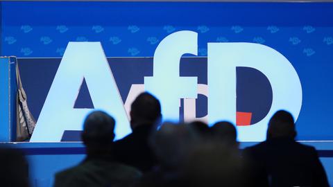 Das AfD-Logo mit Delegierten davor bei der AfD-Europawahlversammlung im August 2023