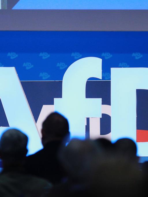 Das AfD-Logo mit Delegierten davor bei der AfD-Europawahlversammlung im August 2023