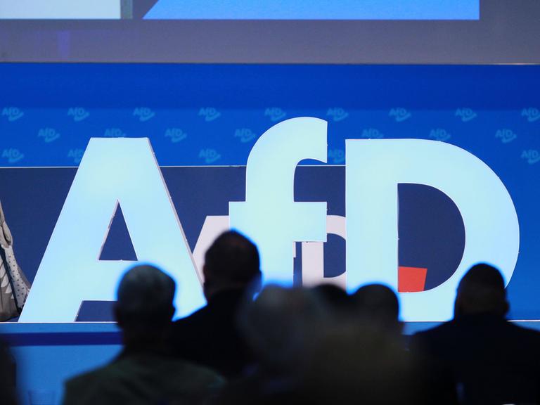 Das AfD-Logo mit Delegierten davor bei der AfD-Europawahlversammlung im August 2023