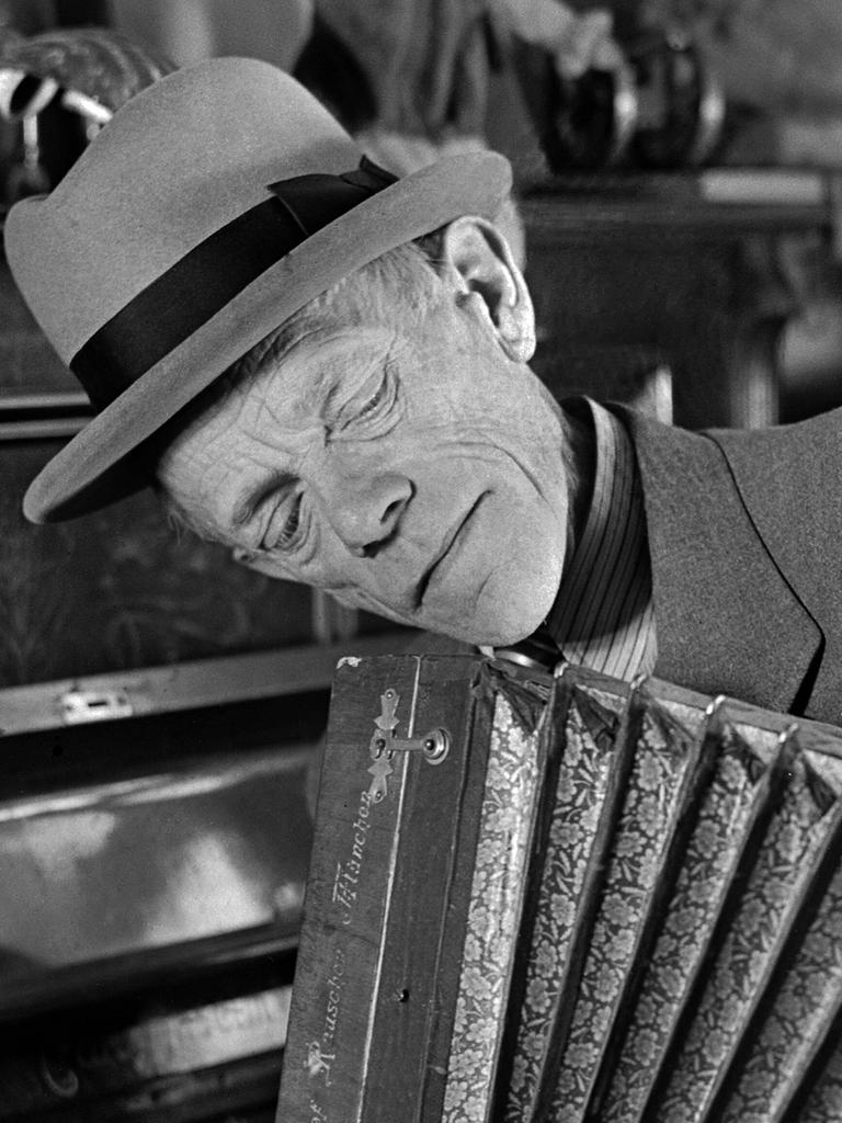 Karl Valentin spielt mit nachdenklichem Gesicht Akkordeon