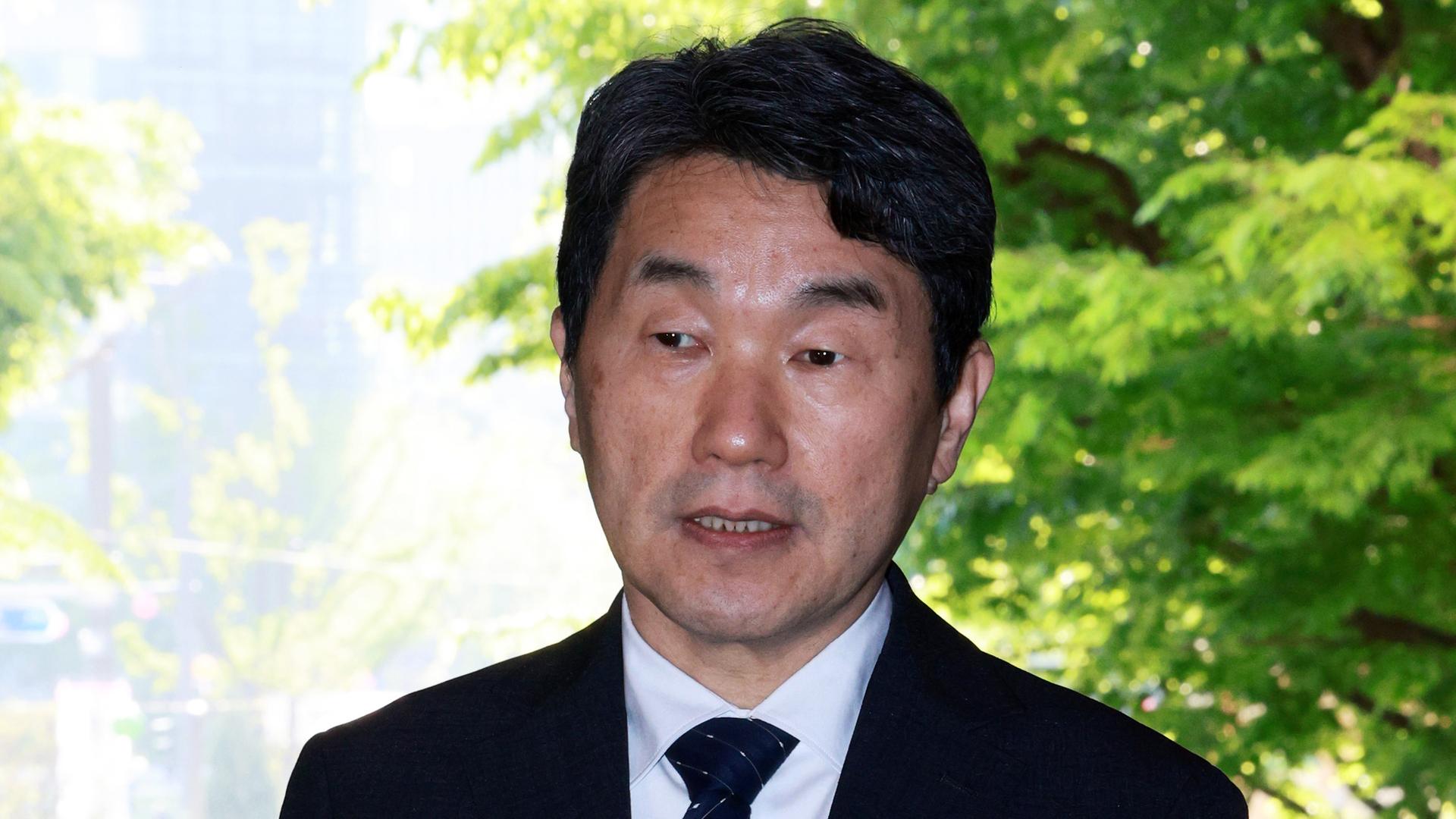 Der neue südkoreanische Übergangspräsident Lee Ju Ho spricht vor Reportern. Er steht vor einem Baum mit grünen Blättern.