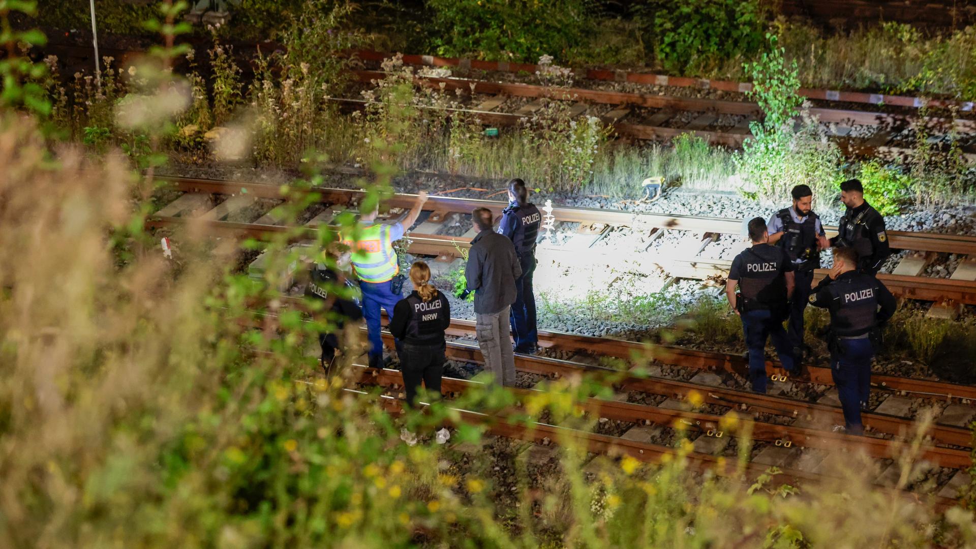 Beamte der Polizei untersuchen das Gleisbett nach einem Brand auf der Bahnstrecke in Wuppertal. Beamte der Polizei untersuchen das Gleisbett nach einem Brand auf der Bahnstrecke in Wuppertal.