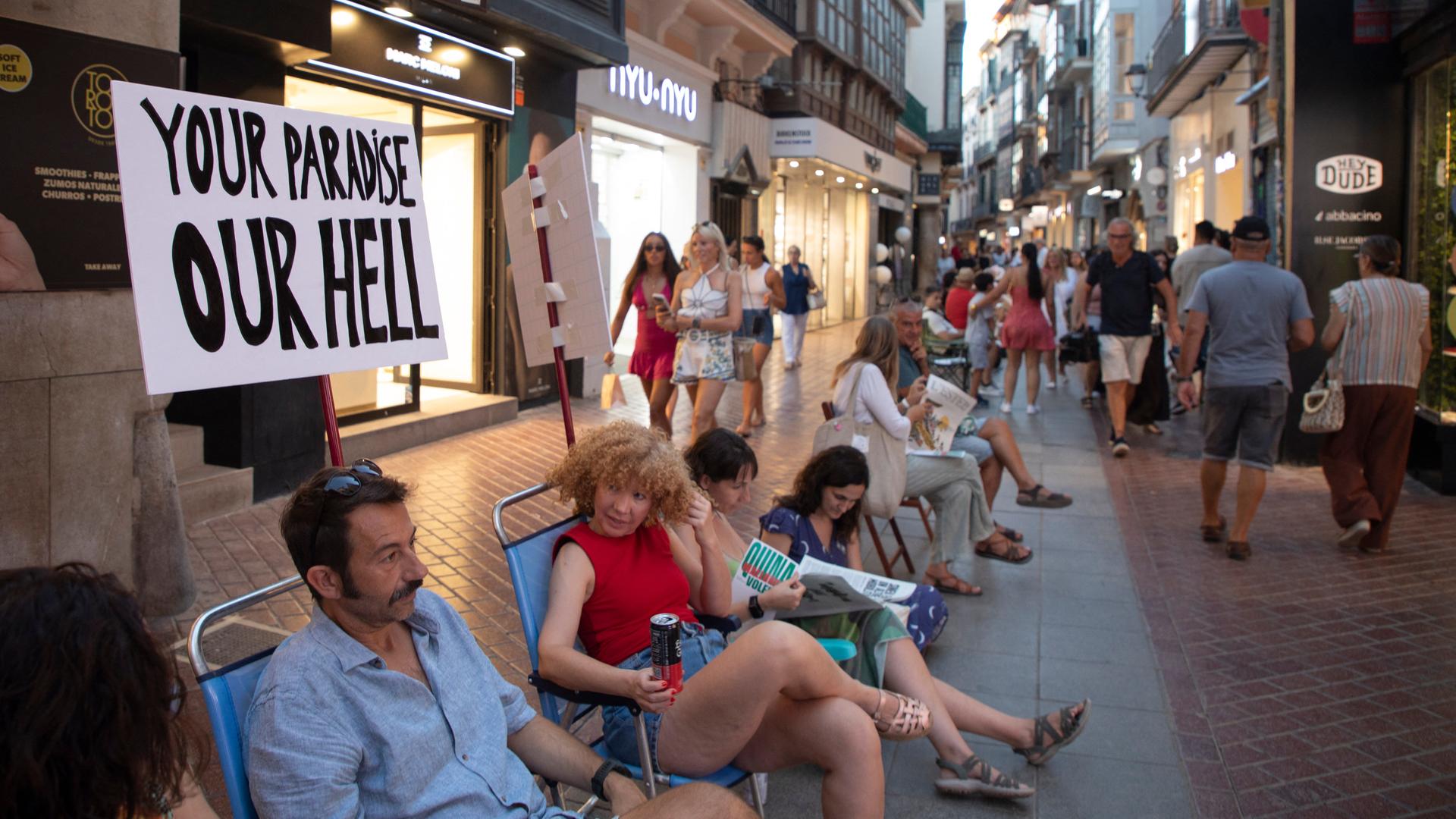 Bewohner protestieren mit einer Stuhl-Kette in den Straßen von Palma gegen den Massen-Tourismus auf Mallorca. Bewohner protestieren mit einer Stuhl-Kette in den Straßen von Palma gegen den Massen-Tourismus auf Mallorca.