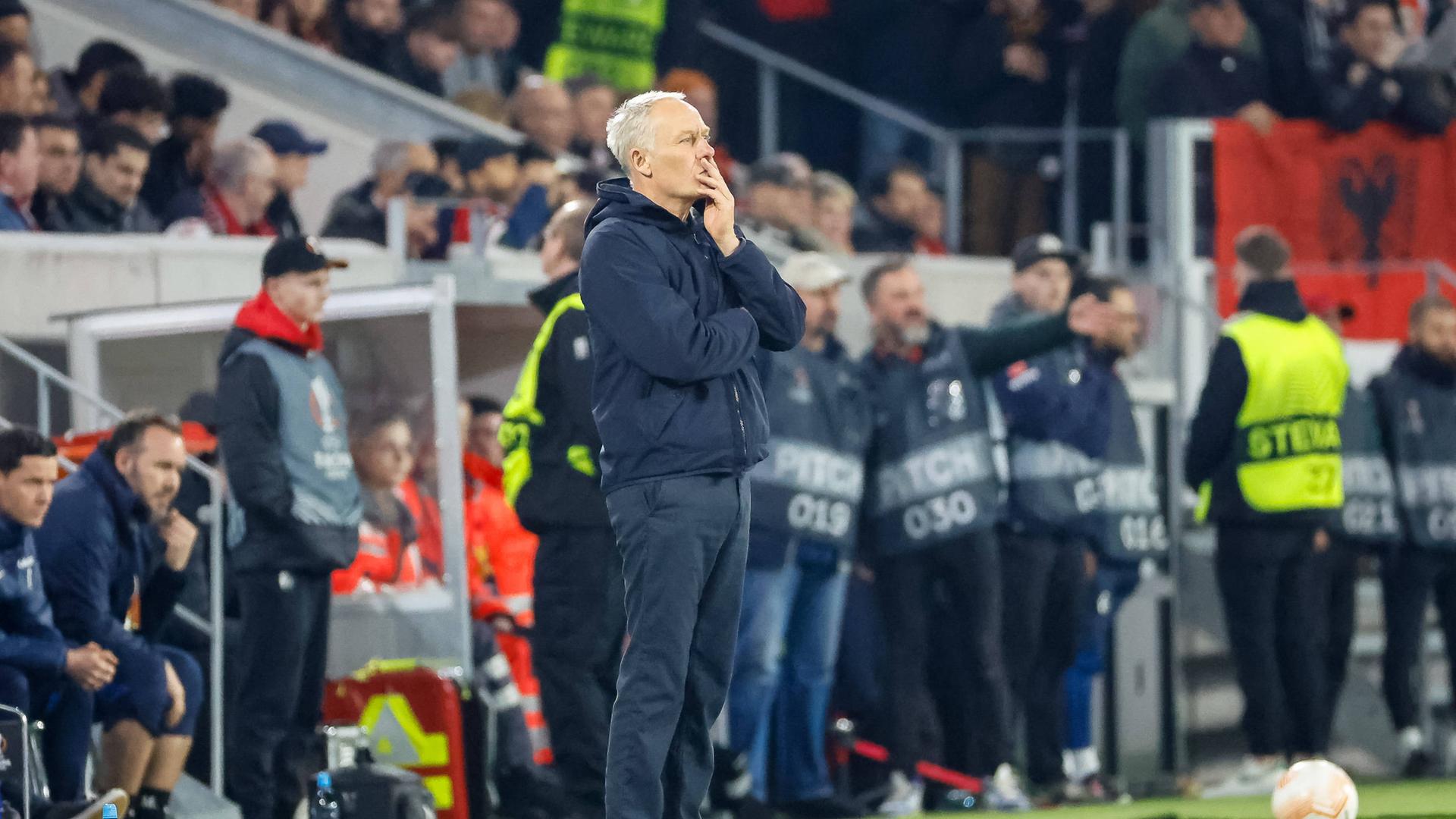 Christian Streich, Trainer des SC Freiburg, steht nachdenklich am Spielfeldrand Spielfeldrand.