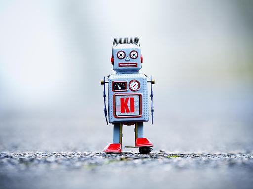 Eine Fotomontage zeigt eine Roboterfigur mit der Aufschrift KI. Eine Fotomontage zeigt eine Roboterfigur mit der Aufschrift KI.