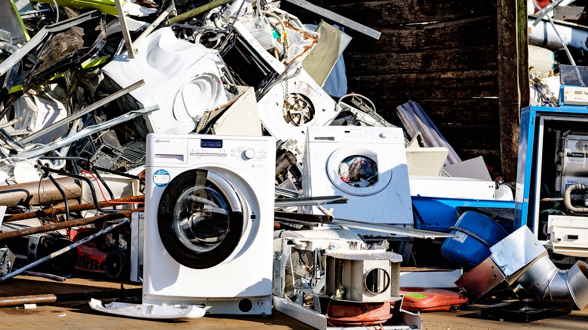 Defekte Waschmaschinen stehen auf einem Haufen Elektroschrott.
