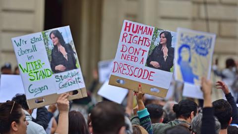 Protest in Frankfurt am Main infolge des Todes der jungen Iranerin Mahsa Amini. Plakate mit einem Foto und dem Schriftzug "Human Rights don't need a dresscode" werden von Demonstrierenden in die Höhe gehalten. Die Proteste richten sich gegen das Mullah-Regime in Teheran.
