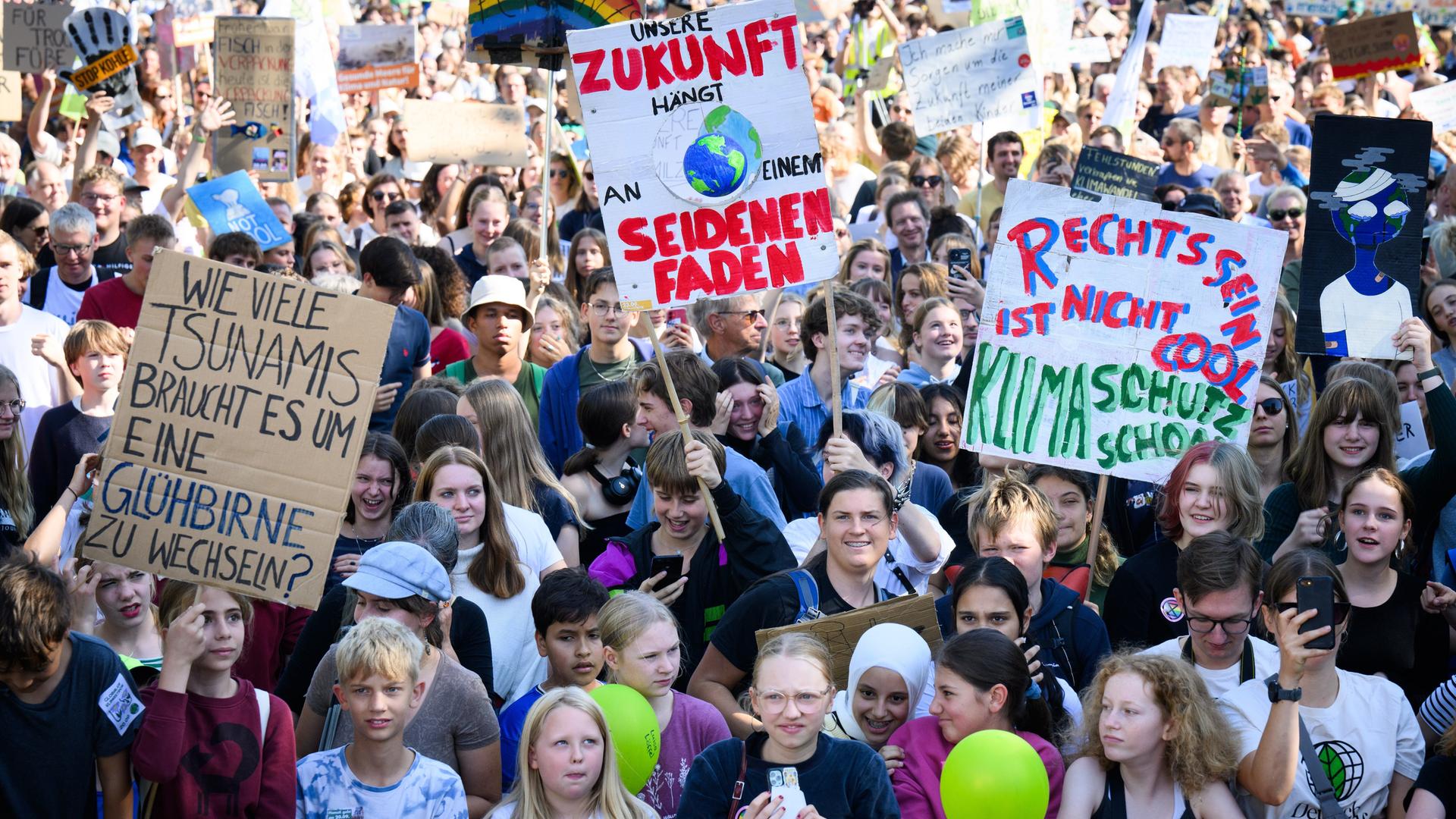 Das Foto zeigt Kinder, Jugendliche und Erwachsene mit Transparenten auf einer Kundgebung für mehr Klimaschutz vor dem Bundeskanzleramt in Berlin.