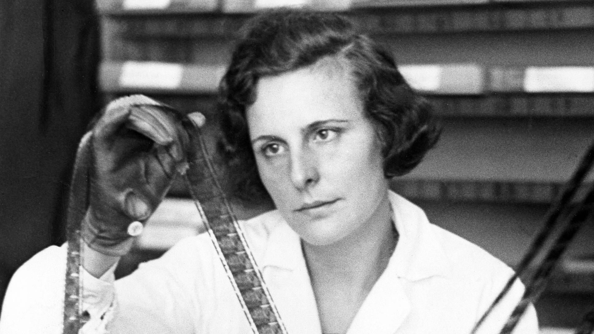 Helene Bertha Amalie 'Leni' Riefenstahl hat einen weißen Kittel an und schaut sich die Negative auf einer Filmrolle an, aufgenommen 1934 bei den Arbeiten zu ihrem Film "Triumph des Willens"