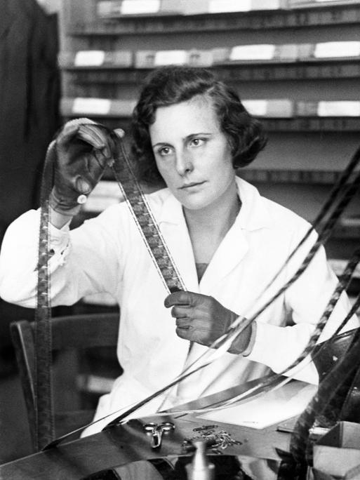 Helene Bertha Amalie 'Leni' Riefenstahl hat einen weißen Kittel an und schaut sich die Negative auf einer Filmrolle an, aufgenommen 1934 bei den Arbeiten zu ihrem Film "Triumph des Willens"