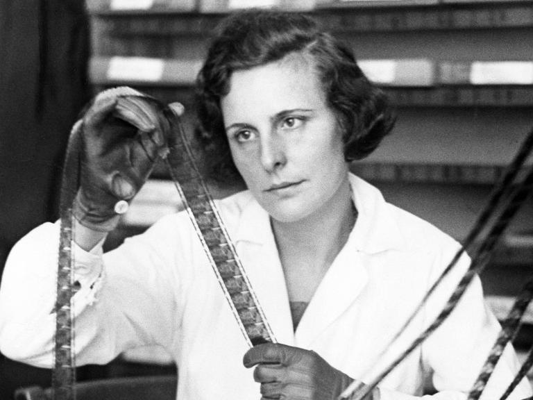 Helene Bertha Amalie 'Leni' Riefenstahl hat einen weißen Kittel an und schaut sich die Negative auf einer Filmrolle an, aufgenommen 1934 bei den Arbeiten zu ihrem Film "Triumph des Willens"