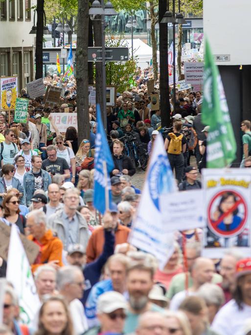 Zahlreiche Menschen mit Fahnen und Transparenten auf einer Straße