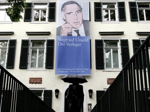 Ein Plakat mit dem Porträt des Verlegers Siegfried Unseld hängt an der Außenfassade 