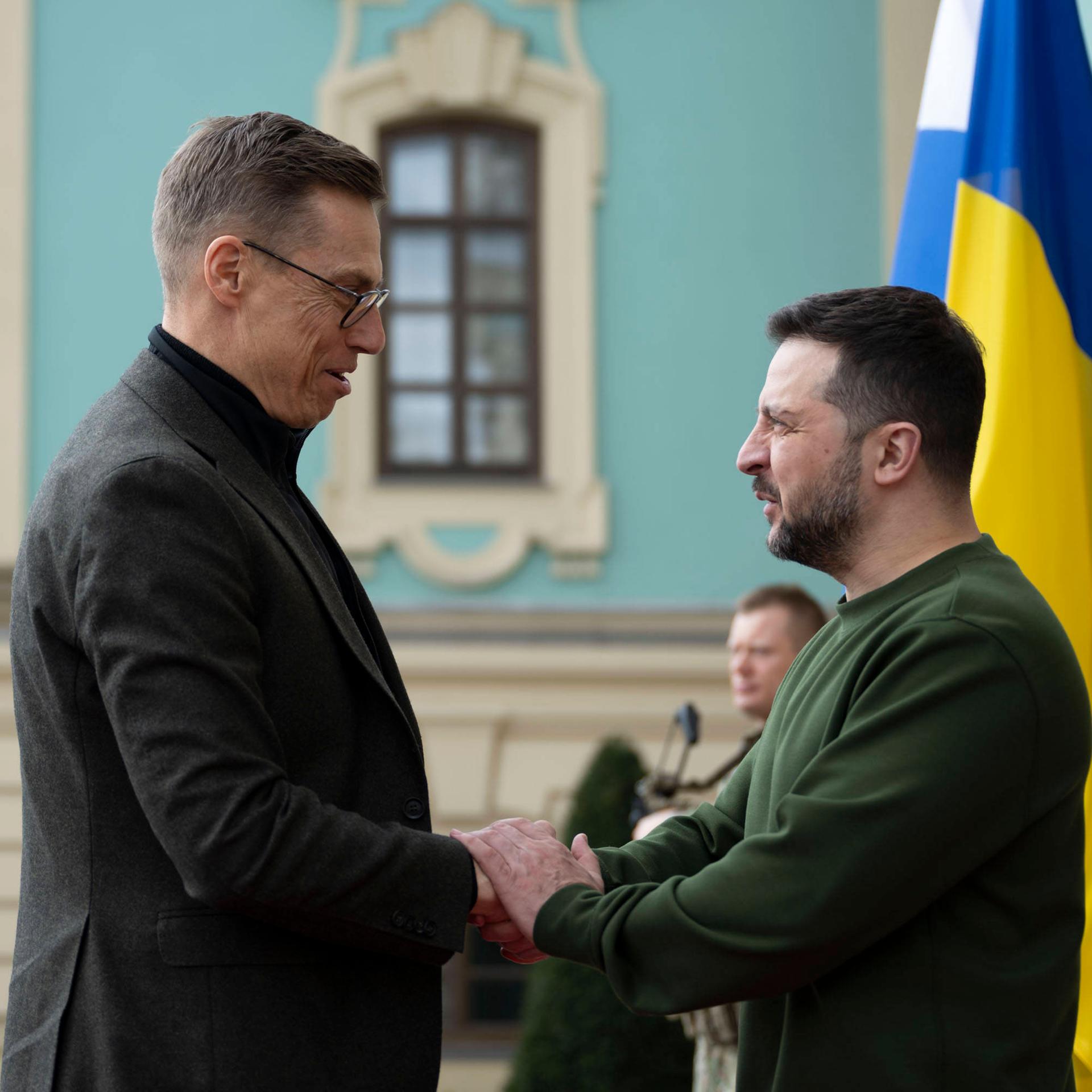 Finnlands Präsident Stubb schüttelt Selenskyj	die Hand.
