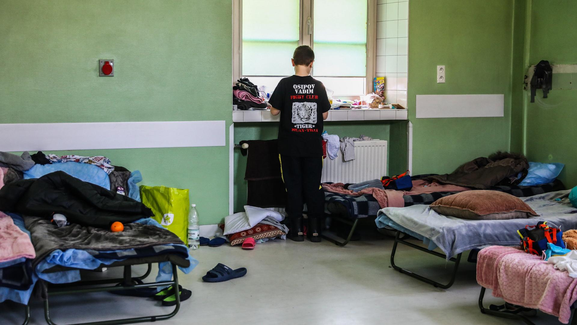 Ein ukrainischer Flüchtlingsjunge steht an einem Fenster in einer Sammelunterkunft in Krakau, Polen 2022.