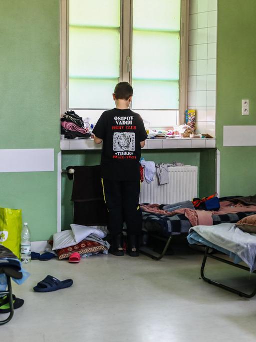 Ein ukrainischer Flüchtlingsjunge steht an einem Fenster in einer Sammelunterkunft in Krakau, Polen 2022.