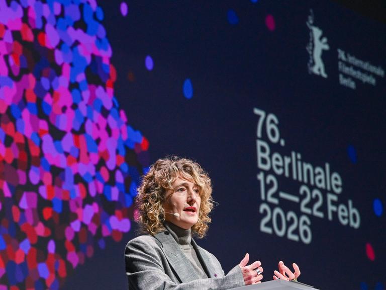 Berlinale-Chefin Tricia Tuttle bei der Jahres-Pressekonferenz der Internationalen Filmfestspiele Berlin vor einer Leinwand mit bunten Punkten und der Aufschrift "76. Berlinale, 16. - 22. Februar 2026"