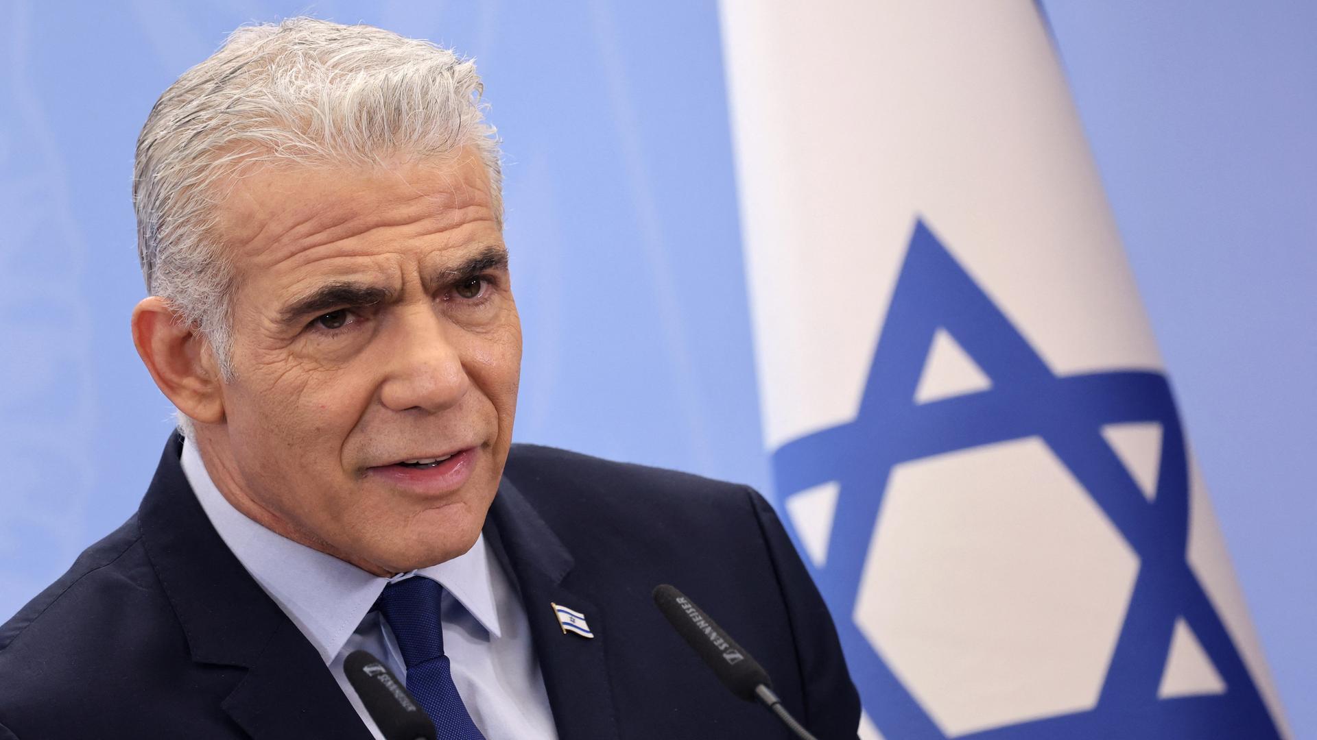 Israels Oppositionsführer Jair Lapid steht vor einer israelischen Flagge. Israels Oppositionsführer Jair Lapid steht vor einer israelischen Flagge.