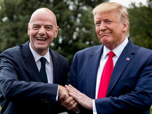 Gianni Infantino und Donald Trump lächeln beim Handshake in die Kamera