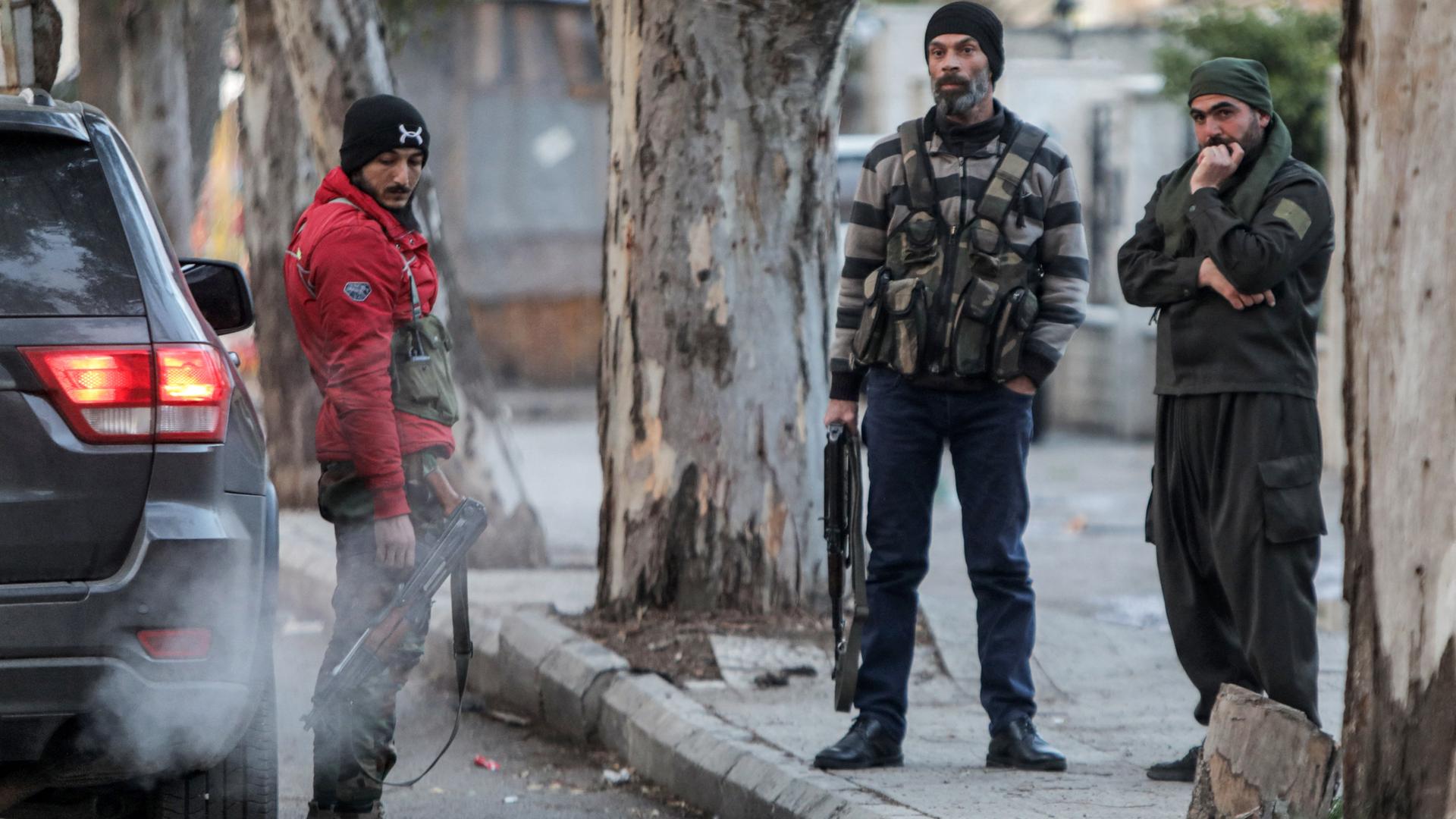 Mitglieder einer lokalen Rebellenmiliz stehen während einer Patrouille in der südsyrischen Stadt Suweida zusammen.