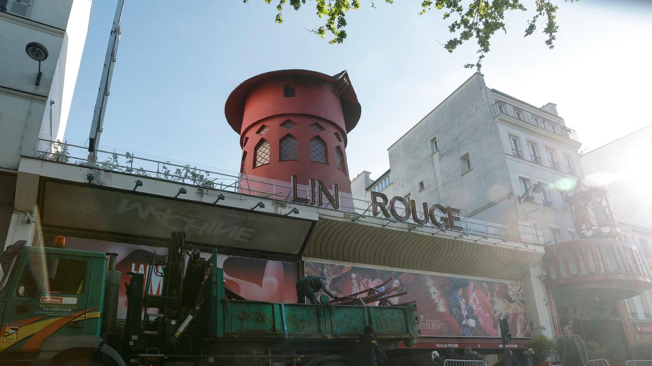Ein Lastwagen steht vor dem Moulin Rouge, von dem die Mühlenräder gestürzt sind.