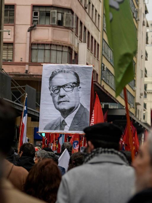 Menschen erinnern am 10. September 2023 in Santiago an den Militärputsch vor 50 Jahren und tragen ein Porträt des damals gestürzten Präsidenten Salvador Allende.