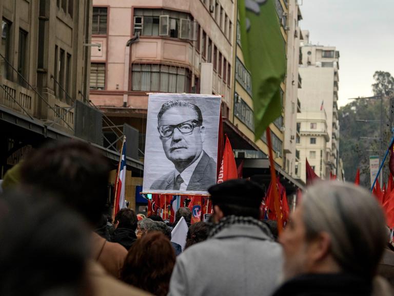 Menschen erinnern am 10. September 2023 in Santiago an den Militärputsch vor 50 Jahren und tragen ein Porträt des damals gestürzten Präsidenten Salvador Allende.
