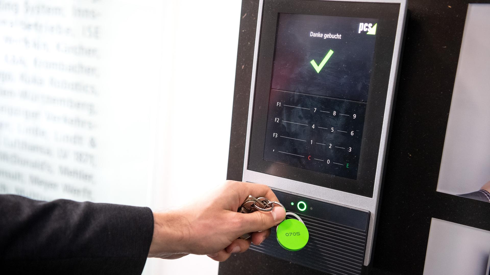 Ein Beschäftigter erfasst seine Arbeitszeit digital an einem Terminal. Ein Beschäftigter erfasst seine Arbeitszeit digital an einem Terminal.