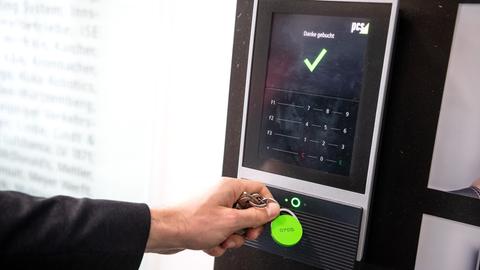 Ein Beschäftigter erfasst seine Arbeitszeit digital an einem Terminal.