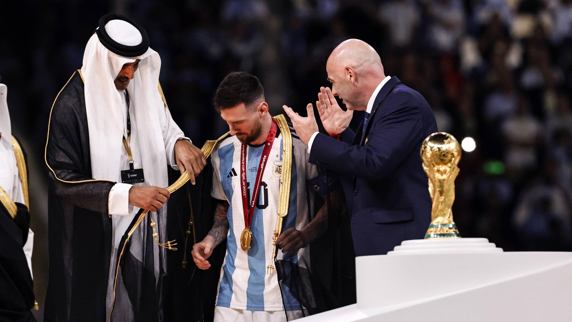 Der Emir von Katar legt Lionel Messi bei der Siegerehrung ein Gewand um.