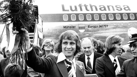 Der deutsche FuÃball-Weltmeister Bernd Hölzenbein (l) wird am Tag nach dem WM-Endspiel 1974 auf dem Rhein-Main-Flughafen begeistert empfangen. 