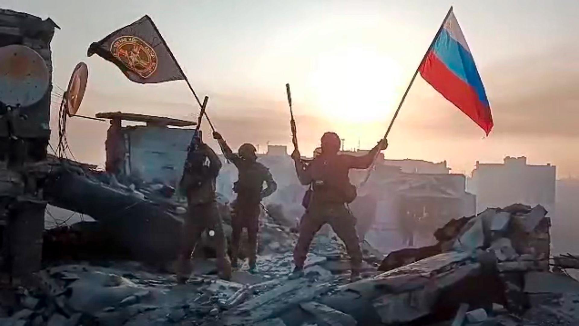 Soldaten schwenken eine Russlandfahne und eine Wagner-Flagge, Videostill aus einem Posting des Prigoschin Press Service