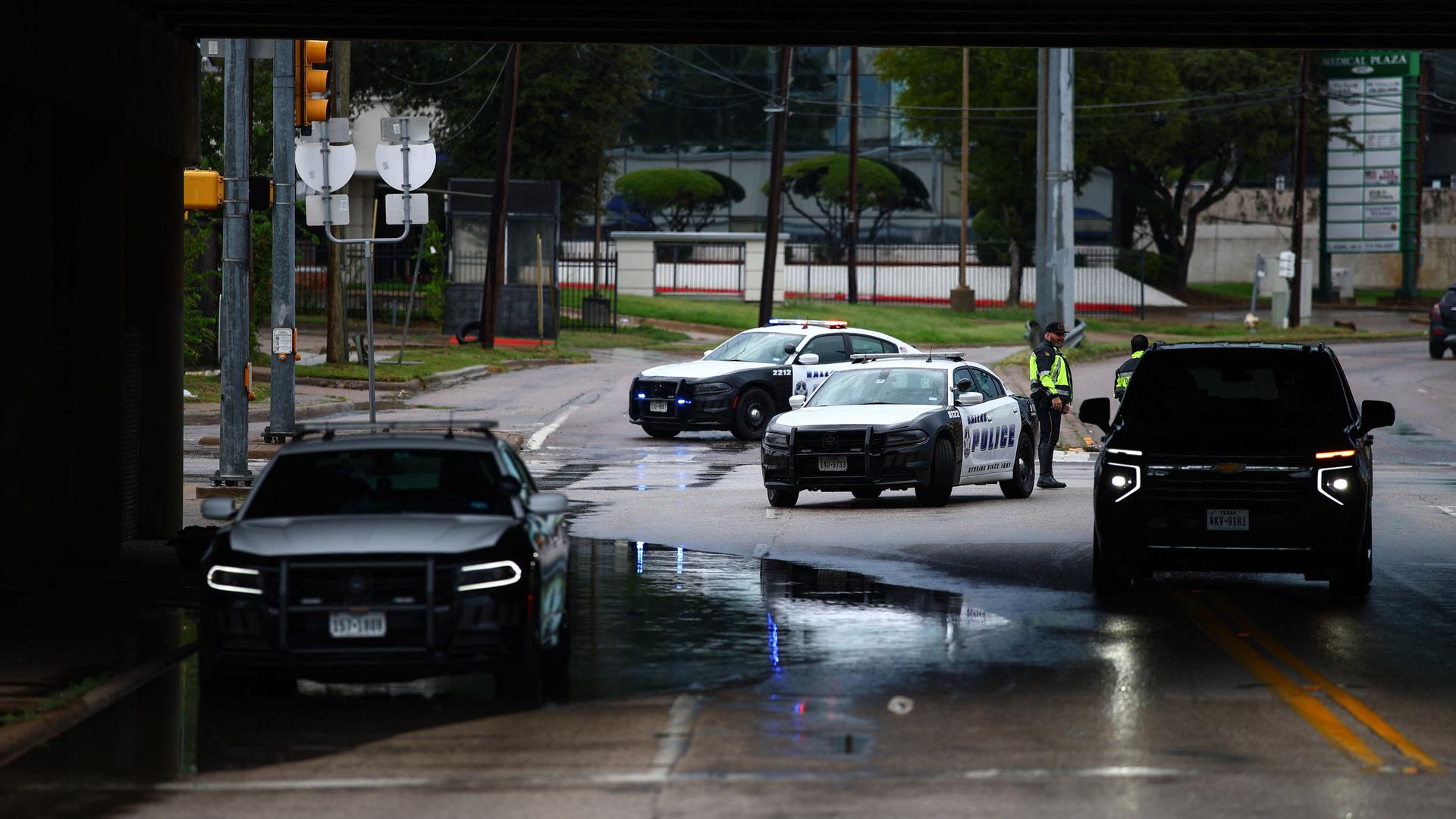 Mehrere Polizeifahrzeuge und ein Polizist stehen in der Nähe eines Gebäudes der US-Einwanderungsbehörde in Dallas, wo es eine Schießerei gegeben hat.