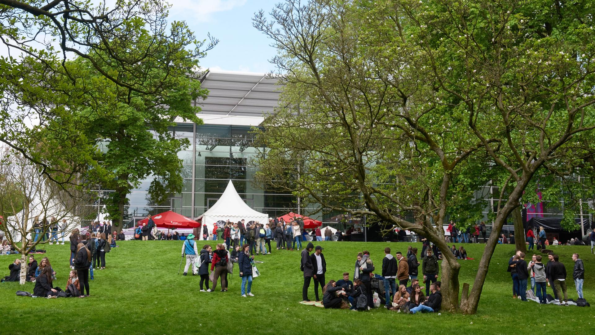 Besucher stehen nach der Eröffnung der Ruhrfestspiele auf der Wiese vor dem Festspielhaus in Recklinghausen. Besucher stehen nach der Eröffnung der Ruhrfestspiele auf der Wiese vor dem Festspielhaus in Recklinghausen.