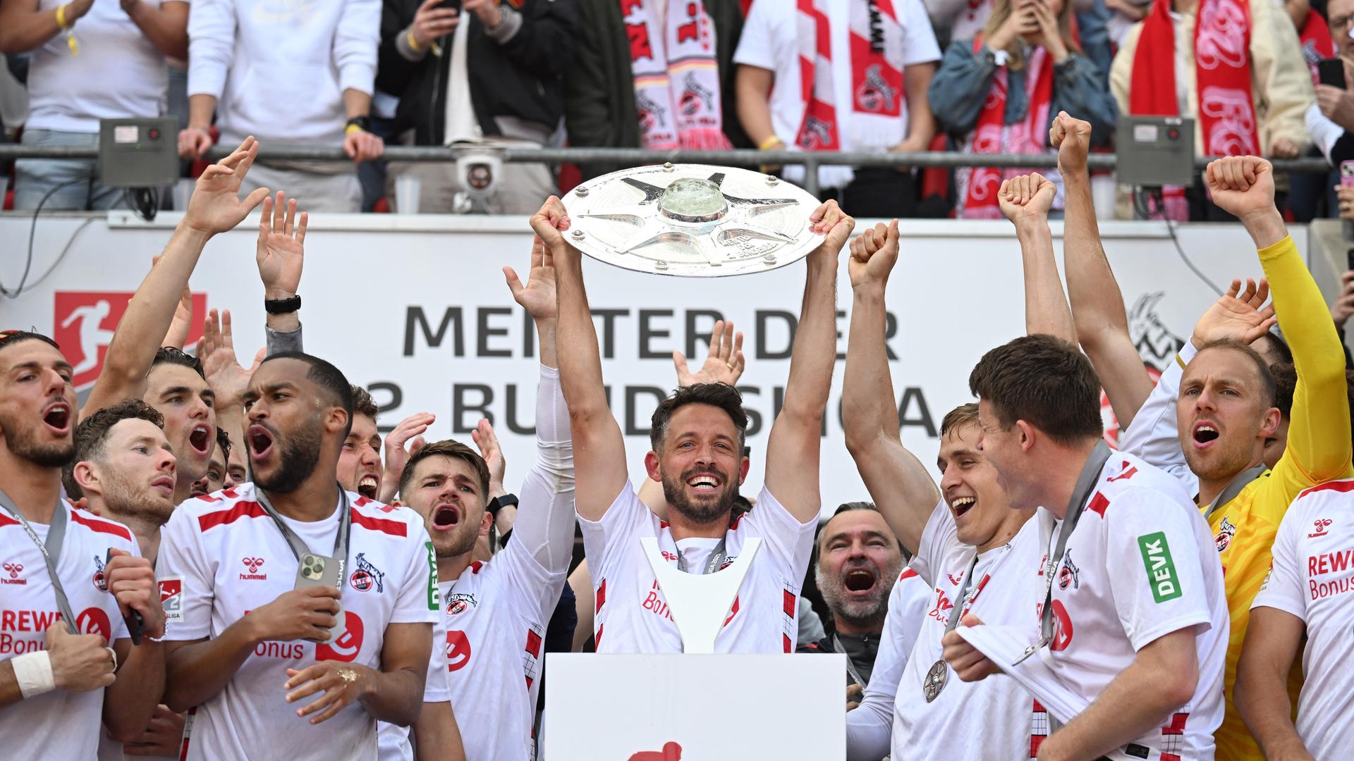 Kölns Fußballer Mark Uth jubelt mit einem Pokal in den Händen. Kölns Fußballer Mark Uth jubelt mit einem Pokal in den Händen.