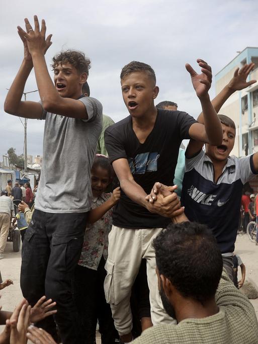 KHAN YUNIS, GAZA – 9. Oktober: Palästinenser, darunter viele Kinder, versammeln sich in der Stadt Khan Yunis, um nach der Verkündung des Waffenstillstandsabkommens im Gazastreifen zu feiern.