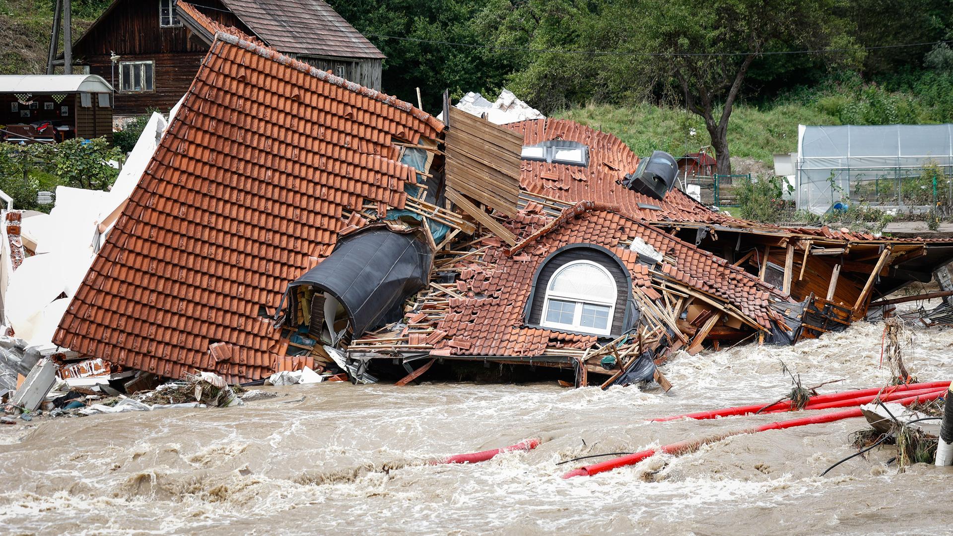 Das Foto zeigt ein zerstörtes Haus im Hoch-Wasser in dem Land Slowenien.