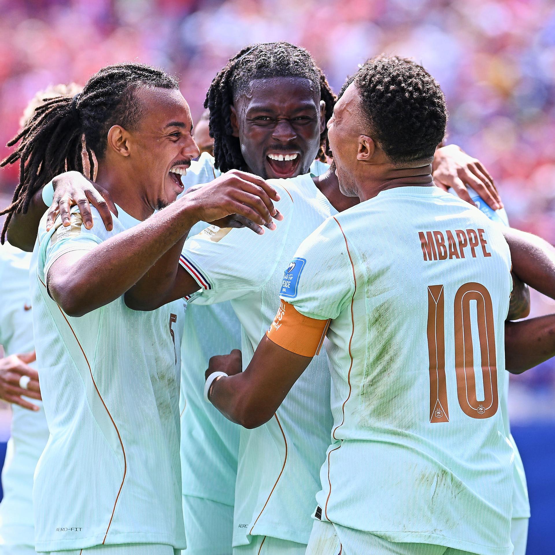 Die französischen Fußball-Nationalspieler Jules Kounde und  Kylian Mbappe feiern nach dem Treffer zum 1:0 gegen Norwegen den Torschützen Ousmane Dembele.