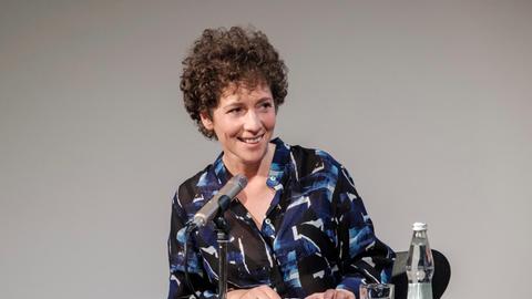 Sasha Marianna Salzmann sitzt auf einem Podium.