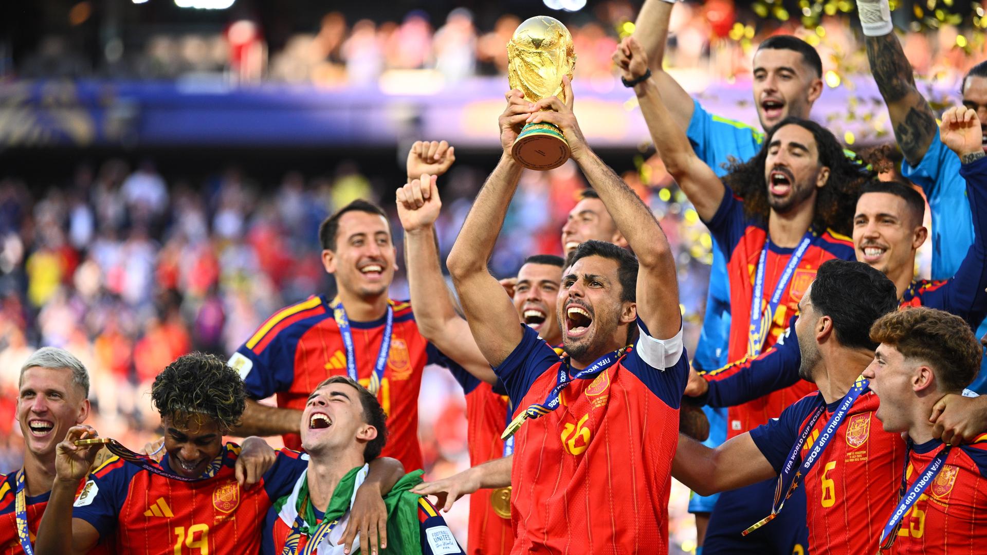 Der spanische Kapitän Rodri hält bei der Siegerehrung die WM-Trophäe in die Höhe und jubelt mit den Teamgefährten über den WM-Titel. Der spanische Kapitän Rodri hält bei der Siegerehrung die WM-Trophäe in die Höhe und jubelt mit den Teamgefährten über den WM-Titel.